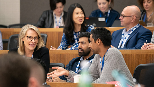 three students talking to each other in class